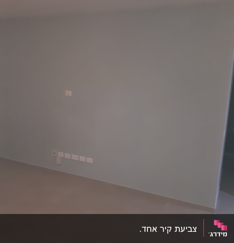 קיר צבוע בצבע אפור בהיר עם שקעים חשמליים